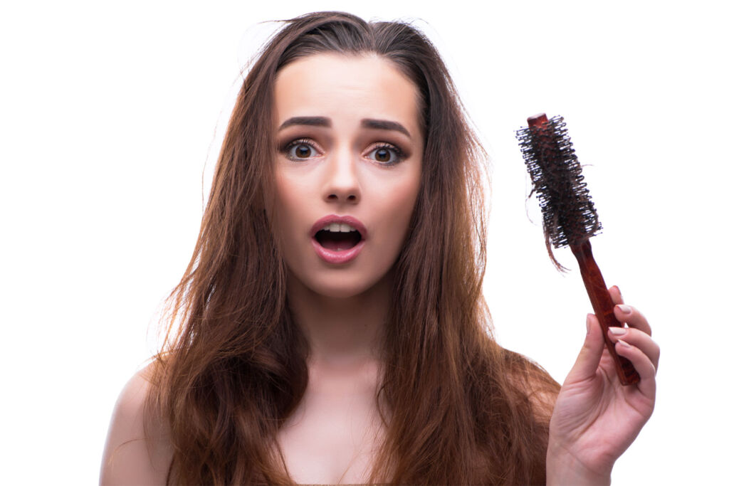 A young woman shocked by the amount of hair on her brush