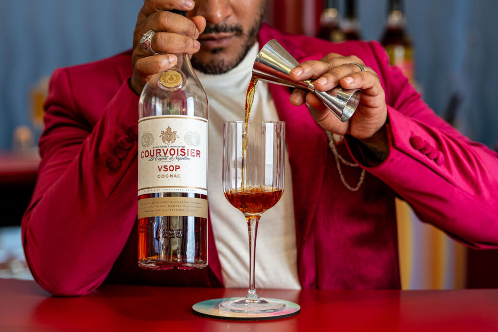 The ambassador of joy pouring some Courvoisier VSOP cognac into a glass