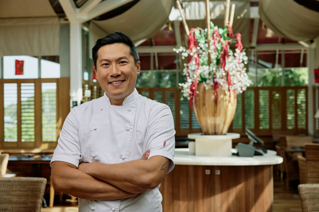 The award-winning chef, standing in the restaurant with arms folder and broad smile