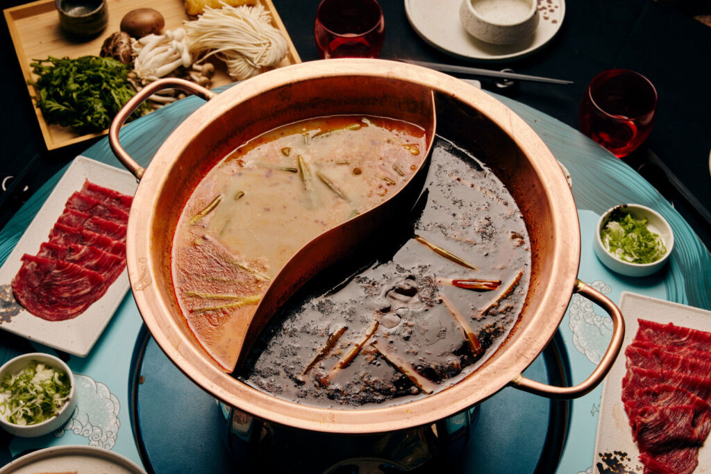 The large copper cooking pot surrounded by fresh ingredients