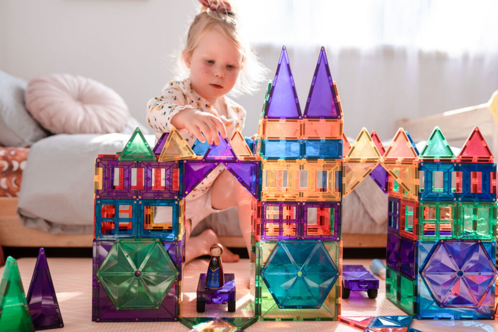 A young girl playing with a fairytale castle