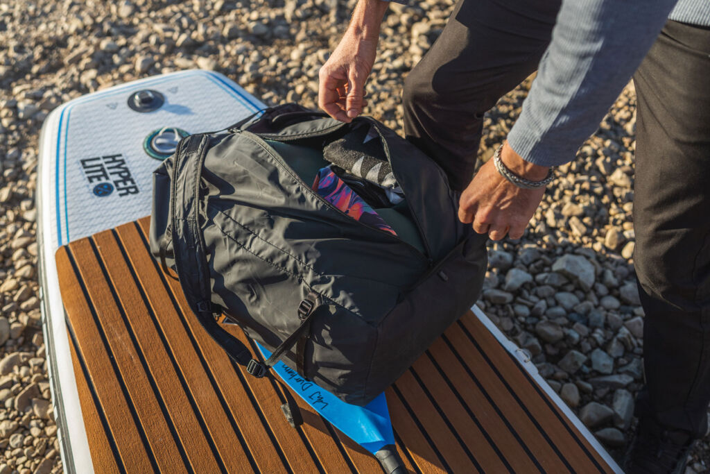 A paddleboarder putting kit away into the collapsible bag