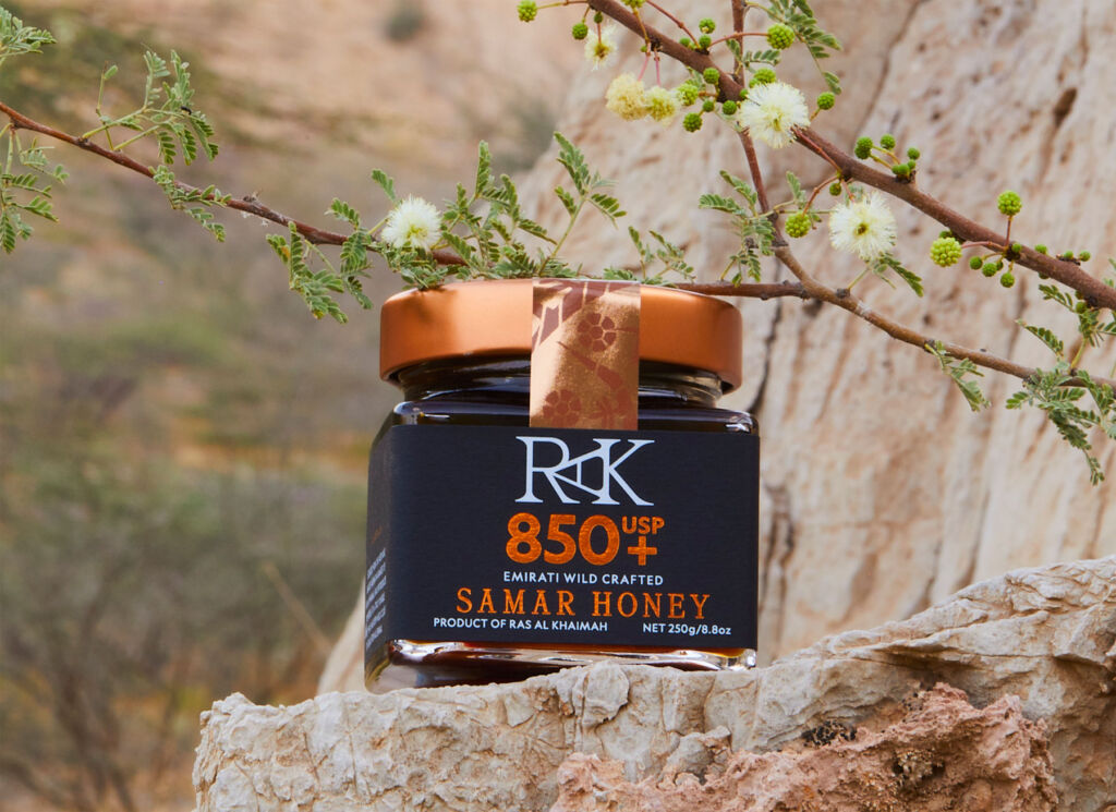 A jar of the honey sitting on a rock ledge in RAK