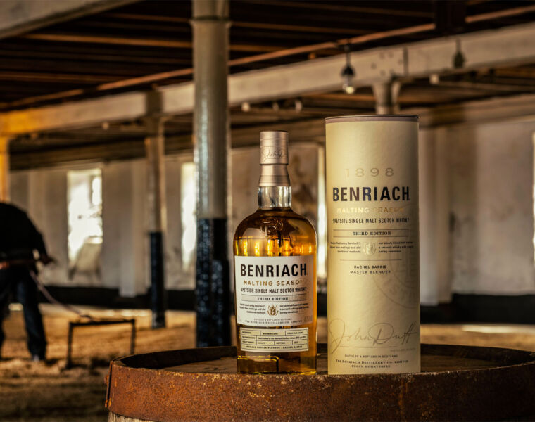 A bottle of Benriach Malting Season Third Edition on a barrel with a workman in the background