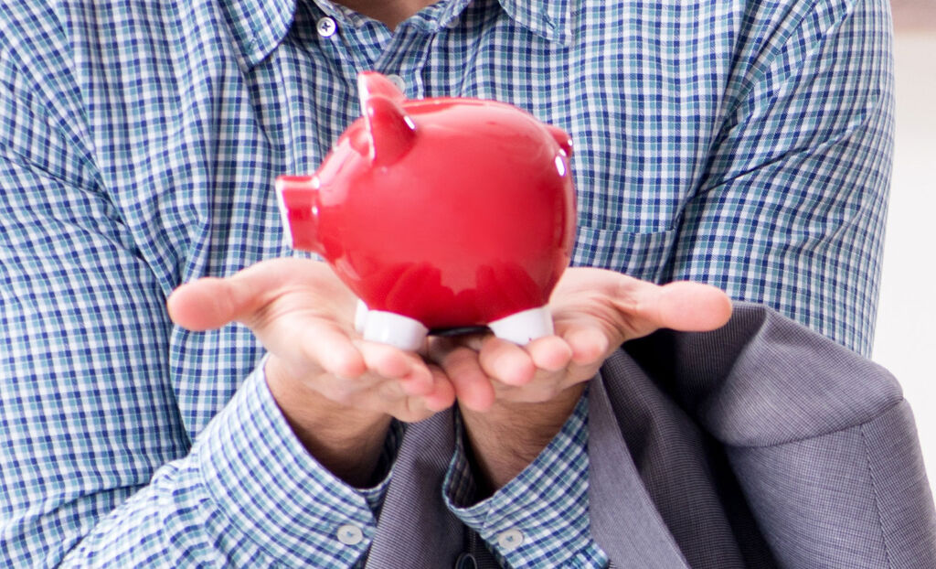 A man holding a red piggy bank in his hands