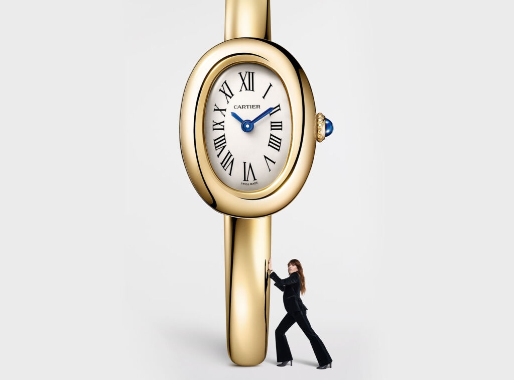 A woman wearing a suit pushing a giant version of the new Baignoire watch