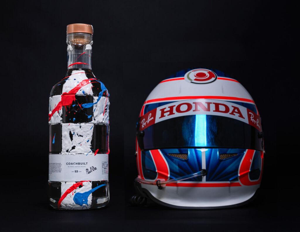 A unique hand painted bottle of Coachbuilt next to a Formula One racing helmet