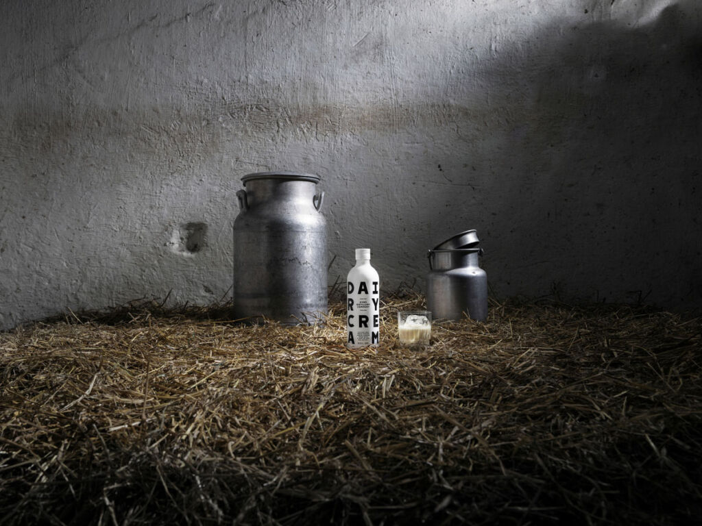 Milk bottles next to a metal churn
