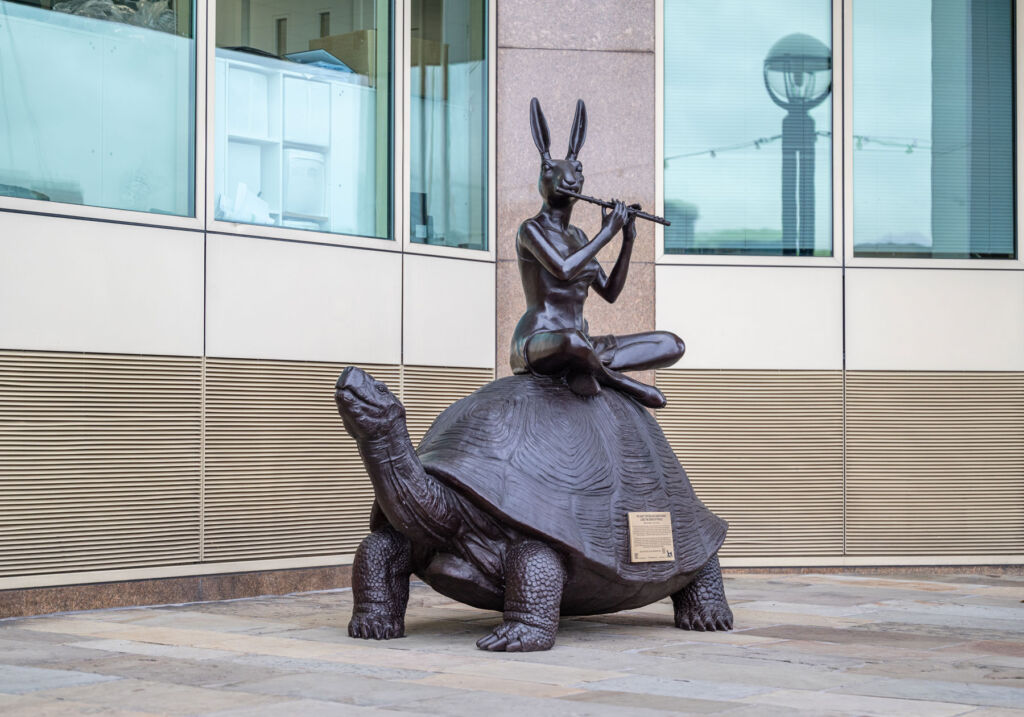 A rabbit playing a flute sitting on the back of a giant tortoise
