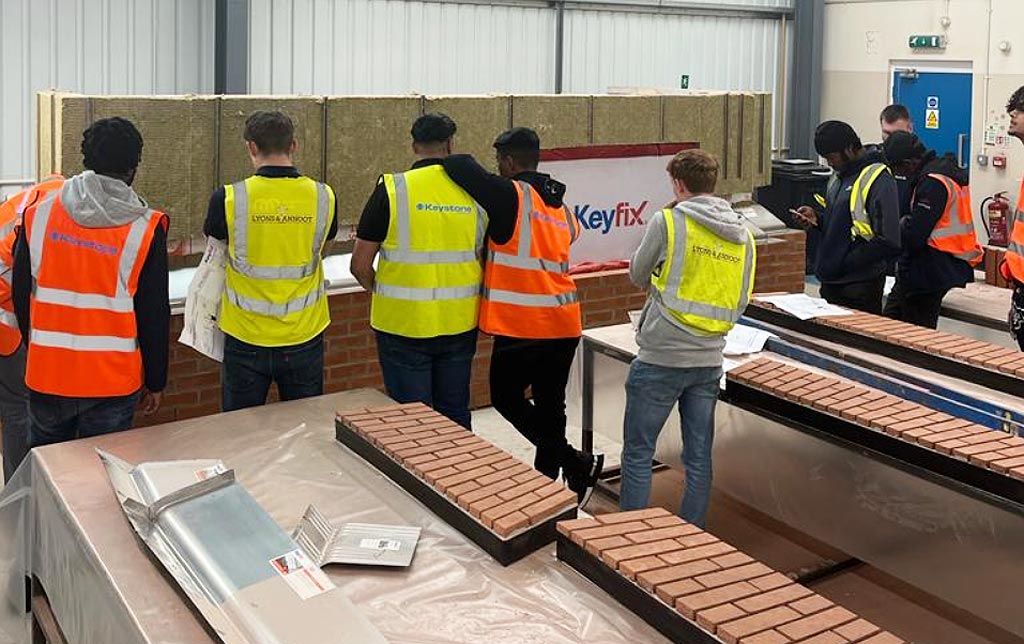 Young people learning the bricklaying trade from experts
