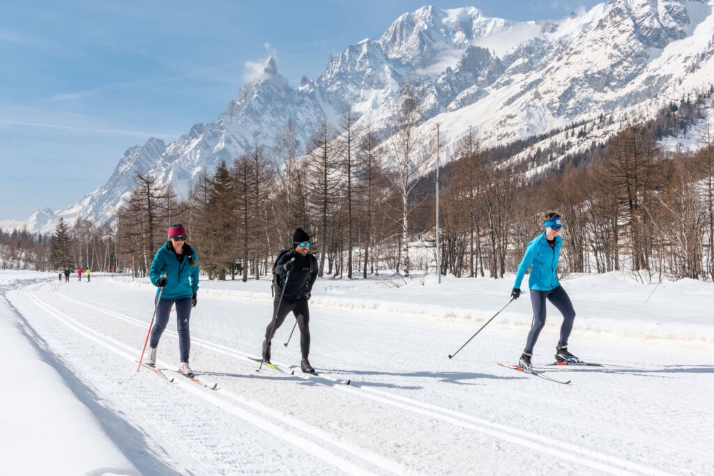 Three people skiing along a trail