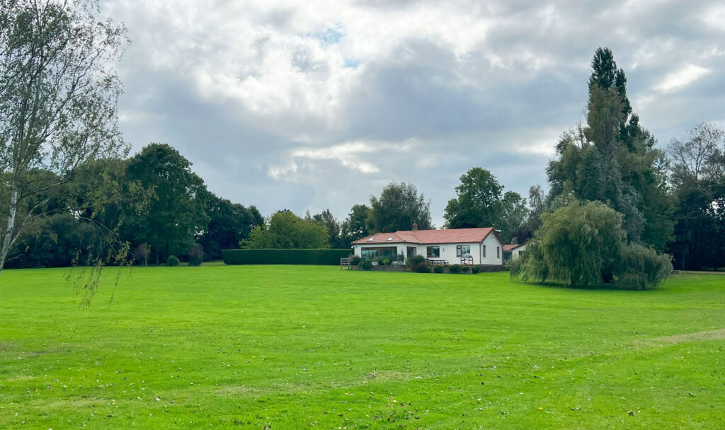 A photograph of the bungalow and the extensive grounds around it