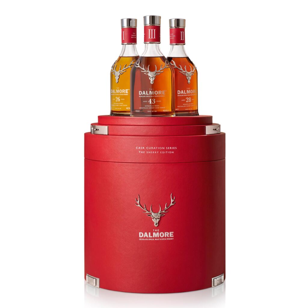 The three bottles inside their red barrel-shaped case