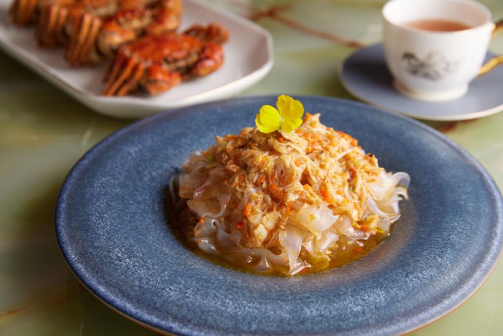 The Braised Hairy Crab Roe with Fish Maw laid out on a blue plate on a table