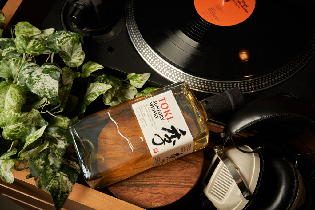 A bottle of Suntory by a record player