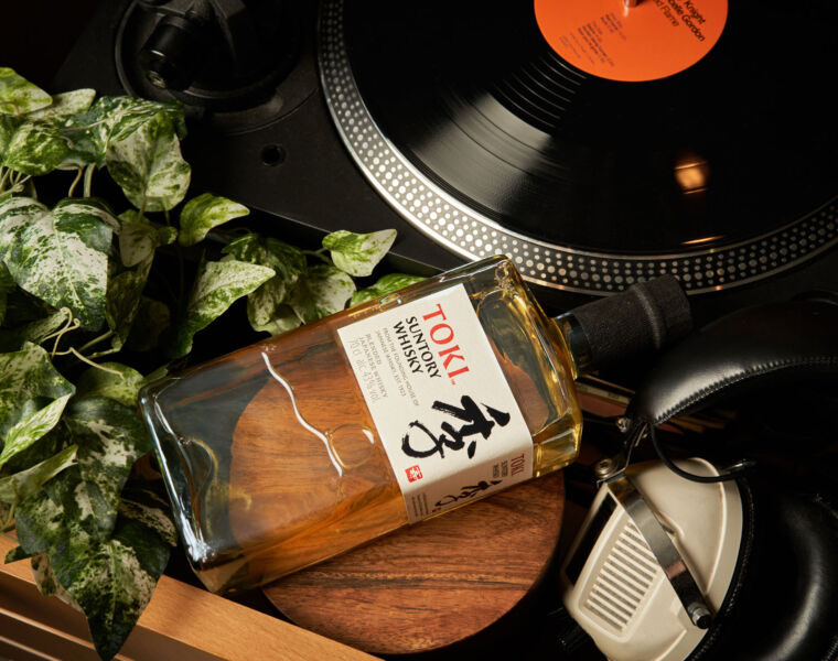 A bottle of Suntory by a record player