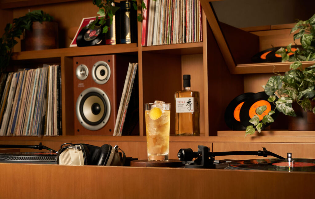 A cocktail next to a turntable playing a record