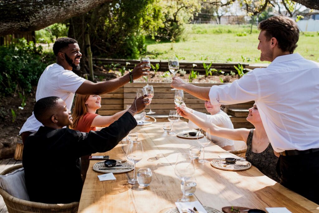 Guests toasting with glasses at the outdoor dining table