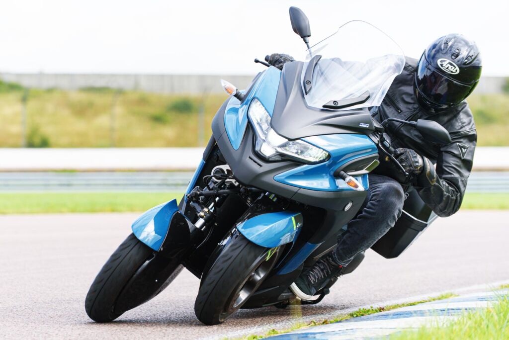 The electric three wheeled hybrid motorcycle cornering at speed on a race track