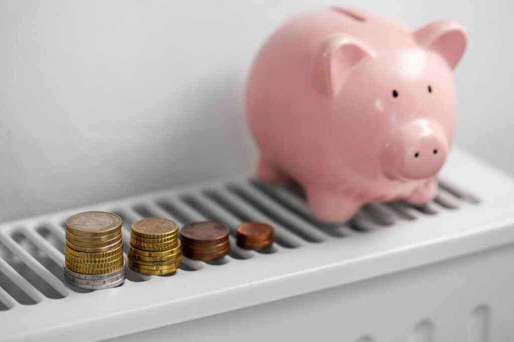 A piggy bank and some spare coins on top of a radiator