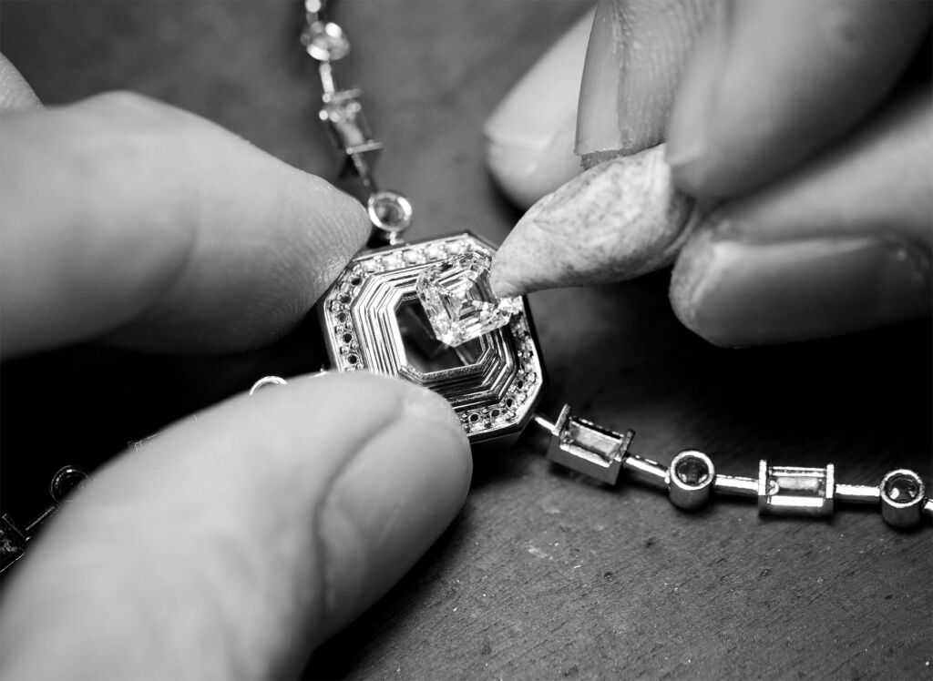 A craftsman inserting a diamond into a piece of jewellery