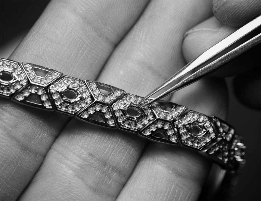 Tweezers being used to place diamonds into a bracelet