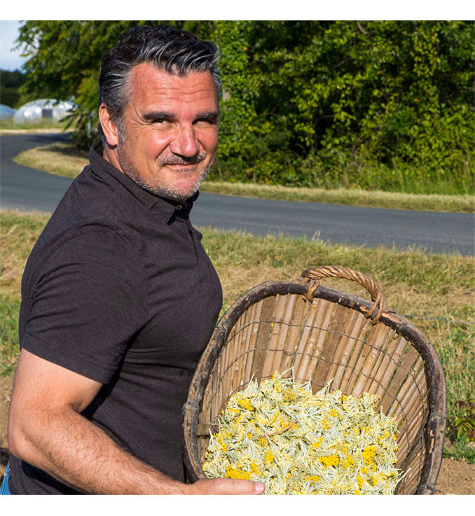 Christophe Amigorena holding a basket of immortelle flowers