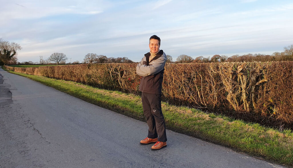A happy looking Paul wearing the boots on a country lane