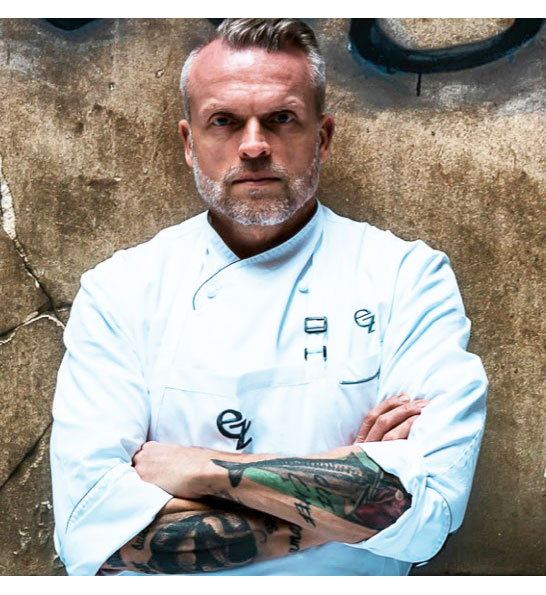 A photograph of the award winning chef with his arms folded