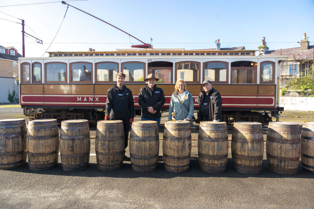 members of the distillery team with the barrels next to the tram