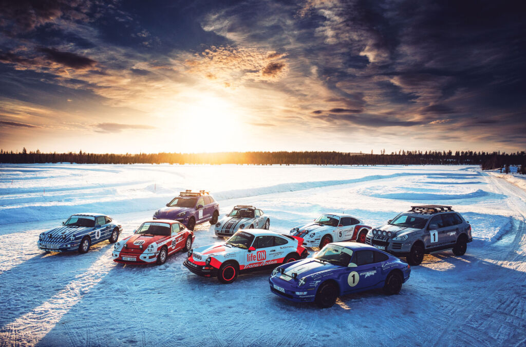 A collection of Porsche sports car on the ice at sunset