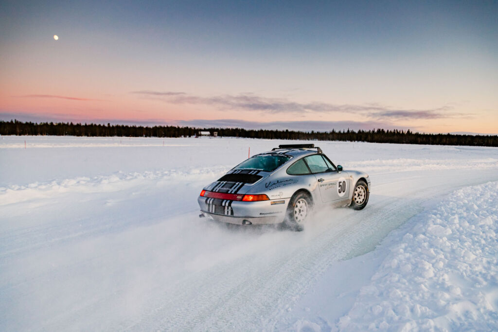 A silver Porsche cornering on the ice track