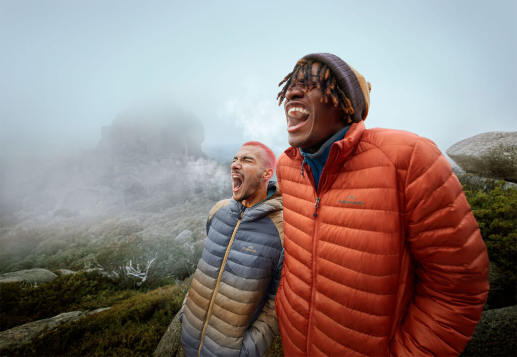 Two young men having fun shouting from the top of a mountain