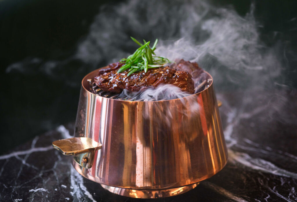 A steaming dish set within a copper container