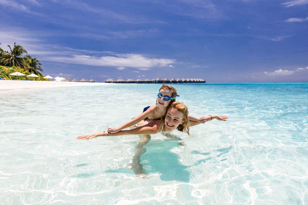 A mother an daughter enjoying the crystal clear waters in the Maldives