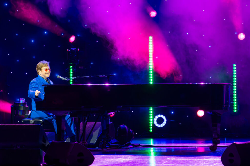 Elton playing a piano on the world-famous stage