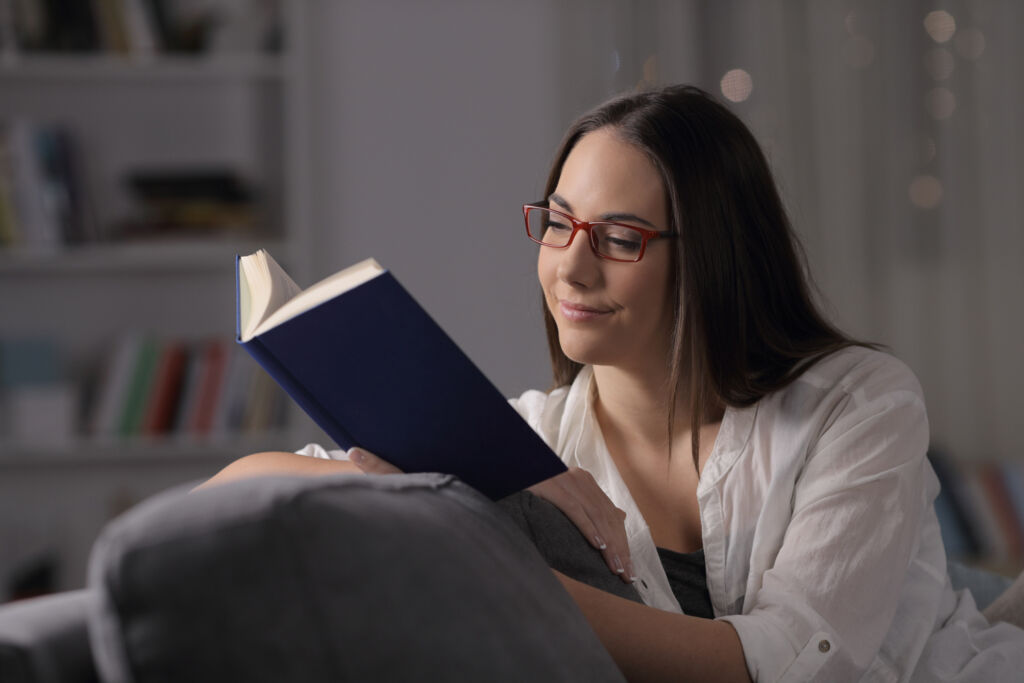 A young woman reading a book in her apartment