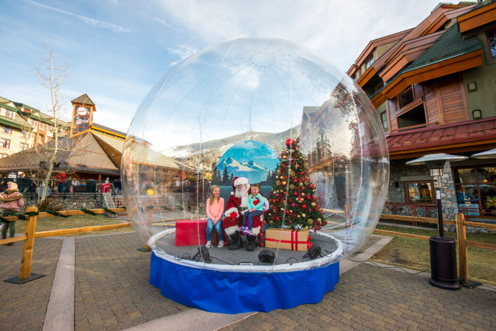 Kids having the photo taken with Santa in a giant show globe