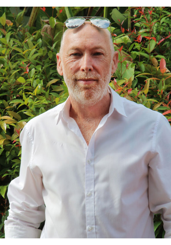 A head and shoulders photograph of Lee outdoors wearing a white shirt