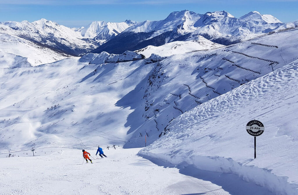 Two people skiing down one of the regions renowned slopes