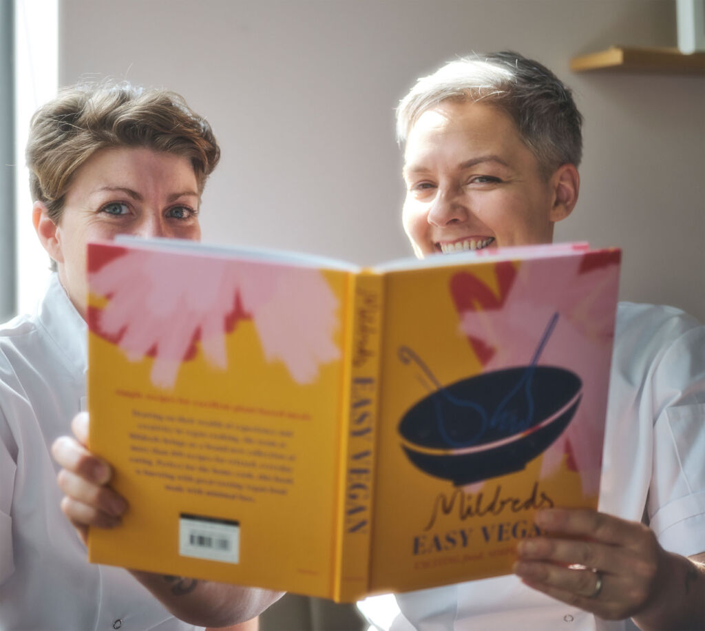 Two women reading the cookbook