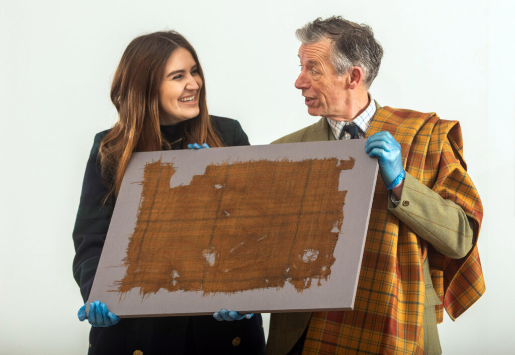 Emma and Peter holding the world's oldest Tartan