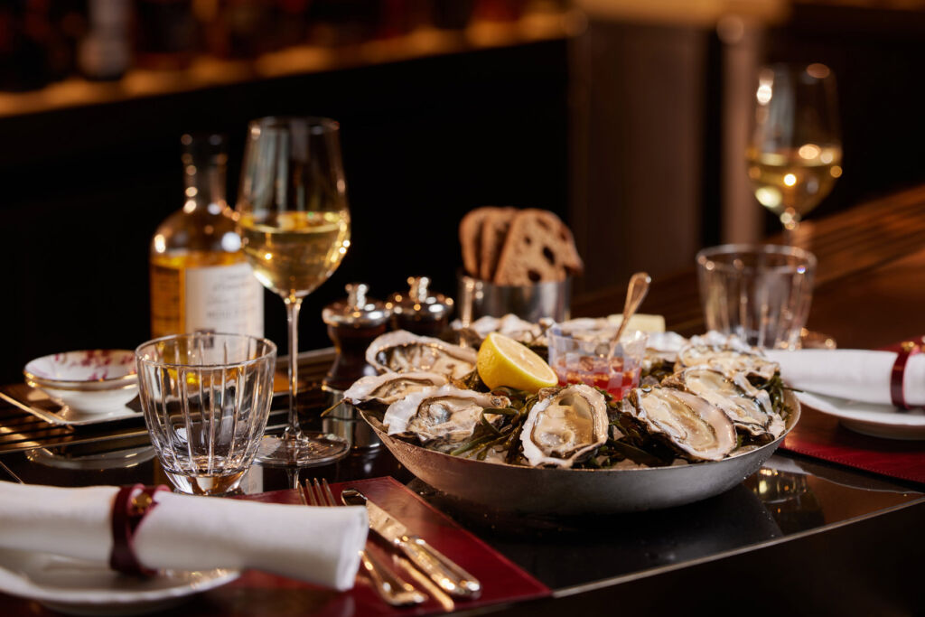 Qura Bar Opens Bringing a Sensory Odyssey, Rare Spirits and Hypnotic Views 14 A table with a plate of fresh oysters