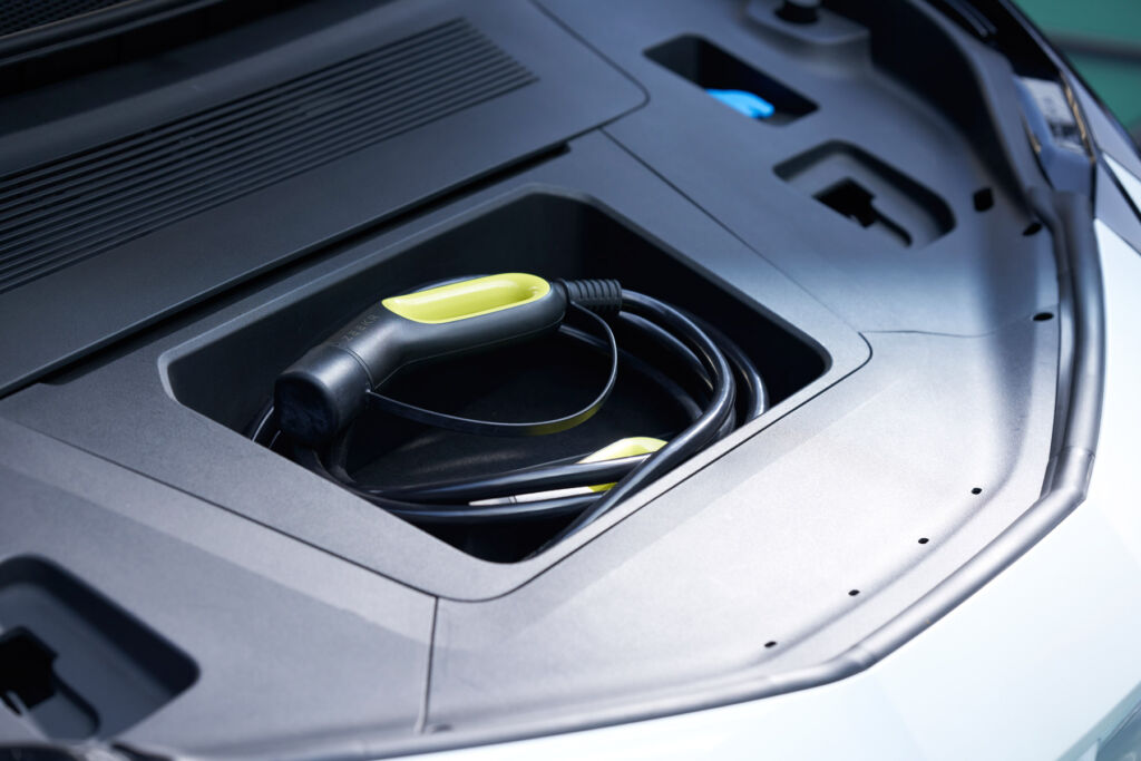 The storage compartment holding the charger cable inside the car