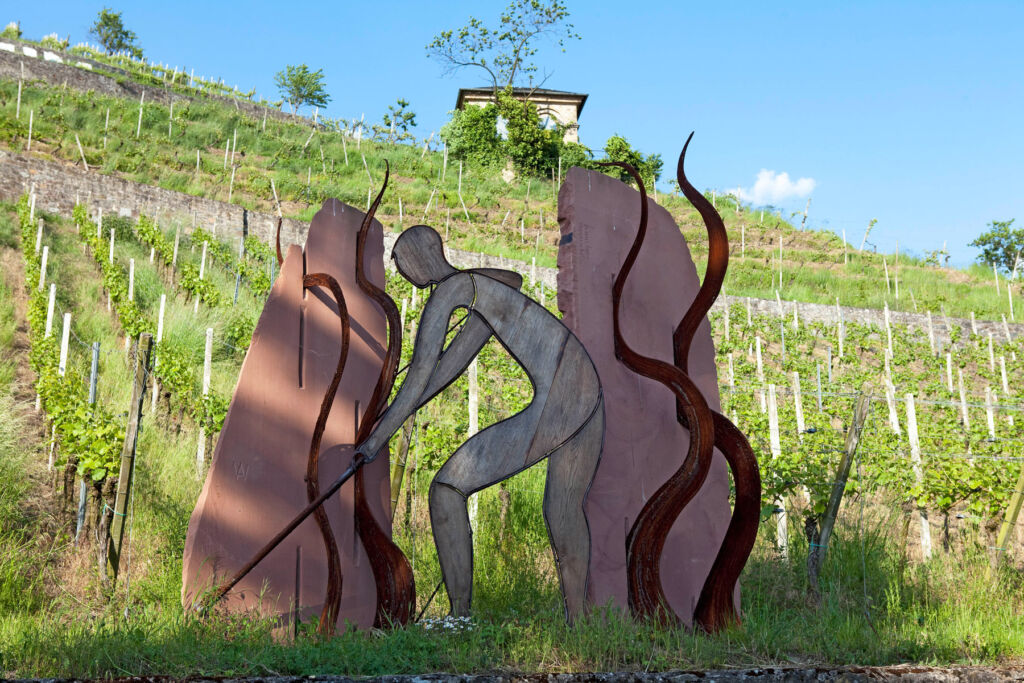 An art piece of a person cultivating the land in a vineyard