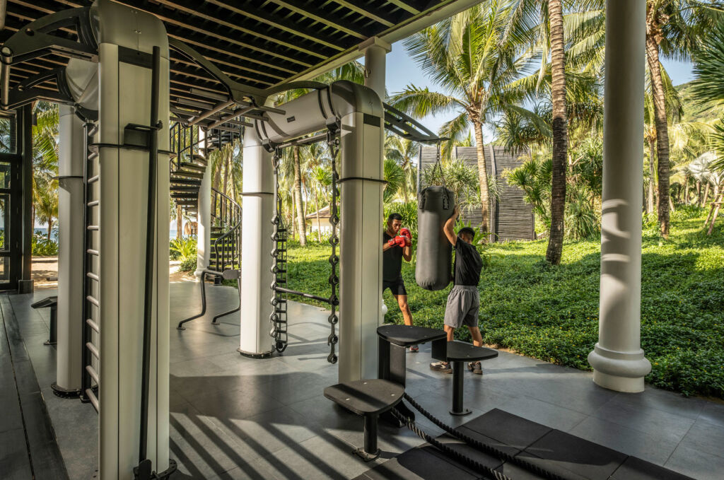 A resort guest being taken through a boxing workout outdoors