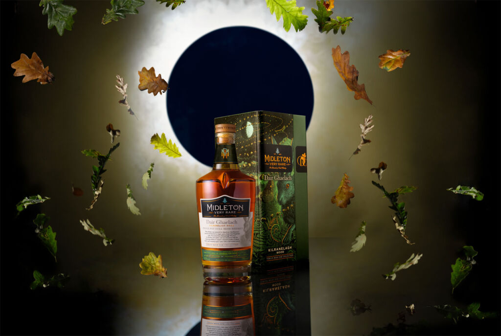 A bottle of Midleton Very Rare Dair Ghaelach Kilranelagh Wood in front of an eclipsed moon with leaves falling around it