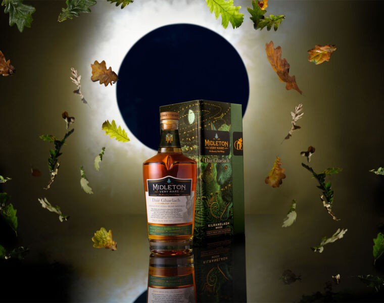 A bottle of Midleton Very Rare Dair Ghaelach Kilranelagh Wood in front of an eclipsed moon with leaves falling around it