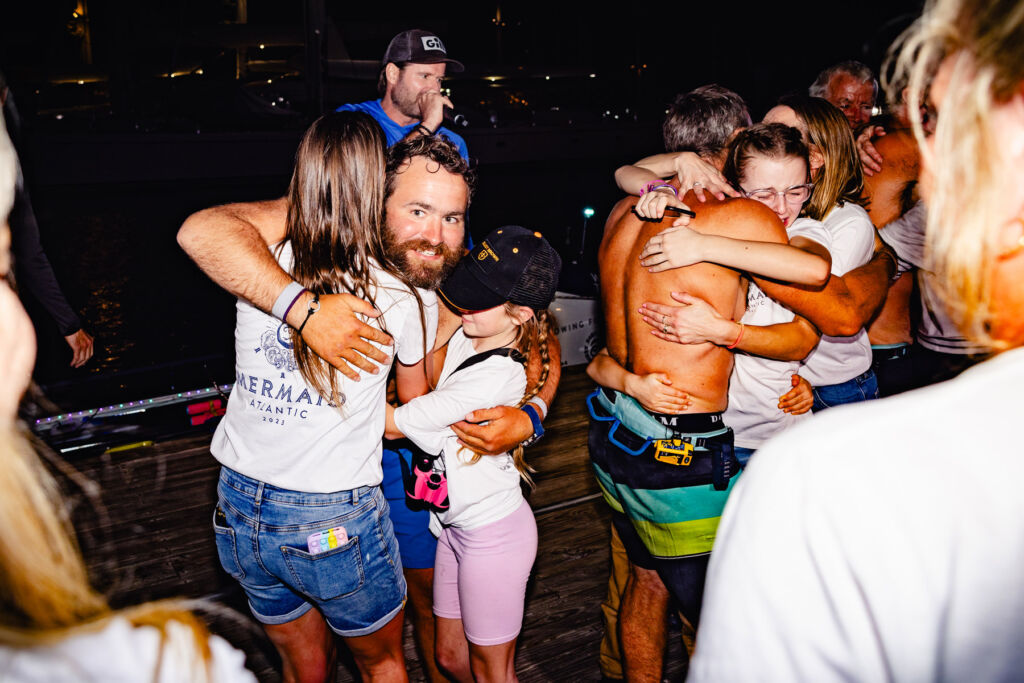 The rowers hugging family members at the end of the charity challenge