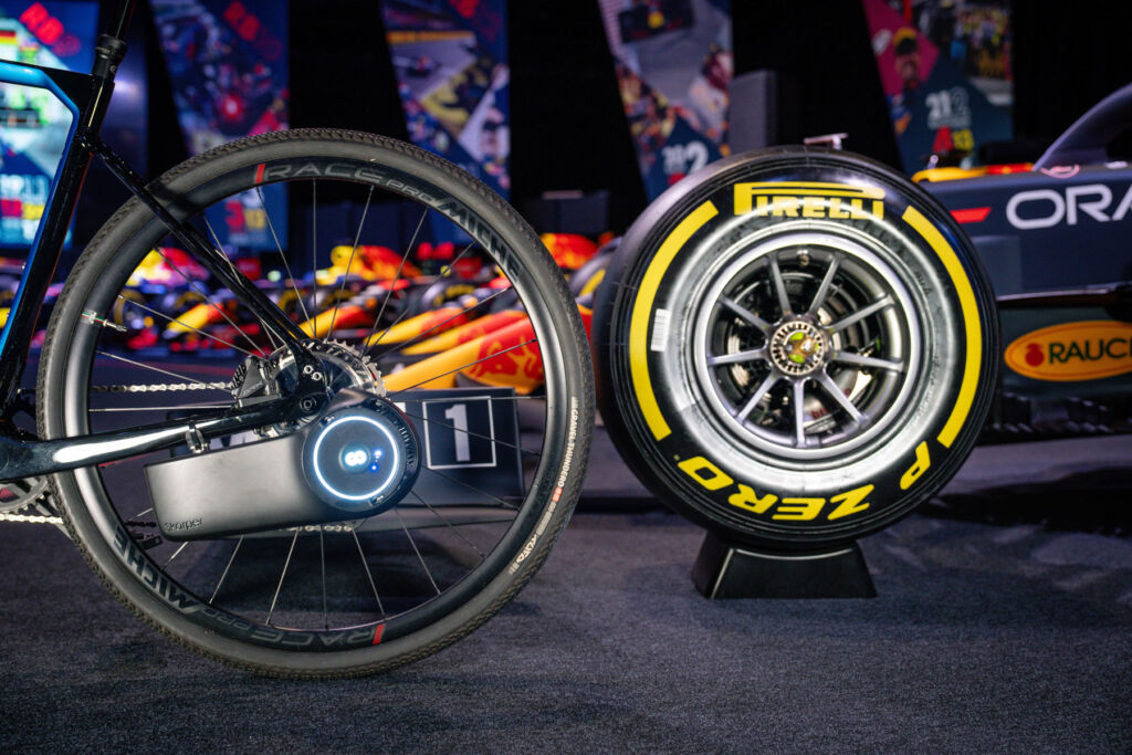 A bicycle wheel next to a F1 racing car wheel